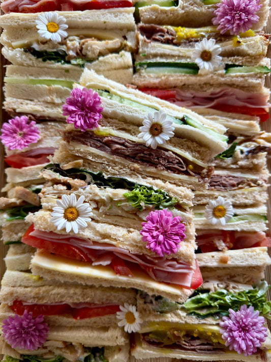 Close-up of gourmet finger sandwiches with edible flowers