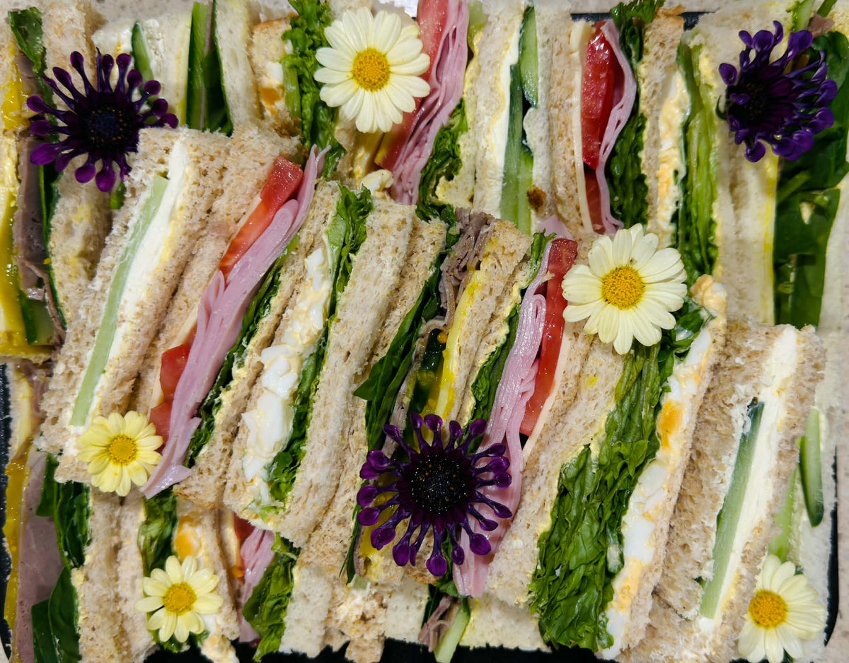 Assorted gourmet finger sandwiches with edible flowers